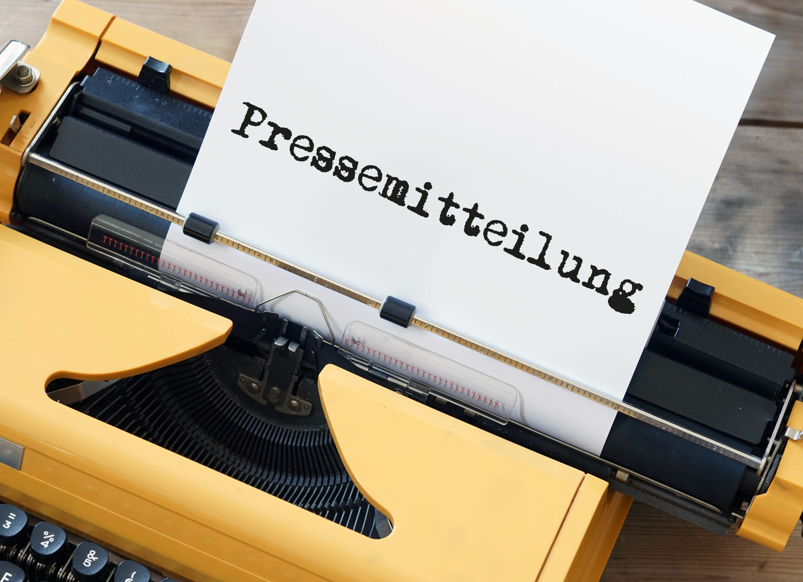 Ein Blatt mit der Überschrift "Pressemitteilung" steckt in einer Schreibmaschine